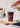 an animated gif of a hand pouring cold foam into an iced coffee drink in a white kitchen