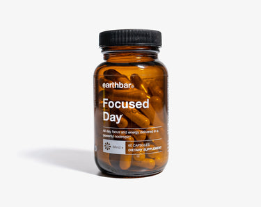 A bottle of Earthbar Focused Day supplements with a label showing the product name and branding.