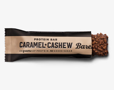 A Barebells protein bar packaging with the text 'Caramel Cashew' and an image of cashew nuts on the front, indicating 20 grams of protein and no added sugar.