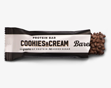 A Barebells protein bar with 'Cookies & Cream' text and a chocolate chip on top, labeled with '20 grams of protein' and 'no added sugar'.
