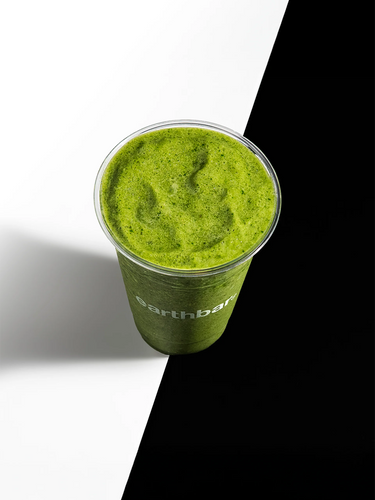 Green smoothie in a cup with 'EarthBar' branding on a black and white background
