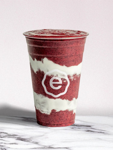 Red and white smoothie cup with a logo on a marble surface