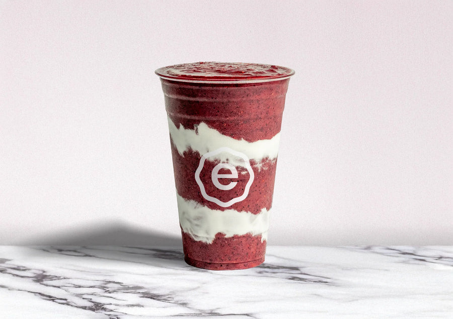 Red and white smoothie cup with a logo on a marble surface