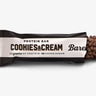 A Barebells protein bar with 'Cookies & Cream' text and a chocolate chip on top, labeled with '20 grams of protein' and 'no added sugar'.